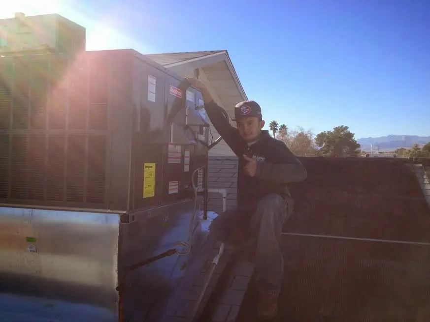 HVAC technician performing AC Tune-Up on a rooftop unit in Forest City